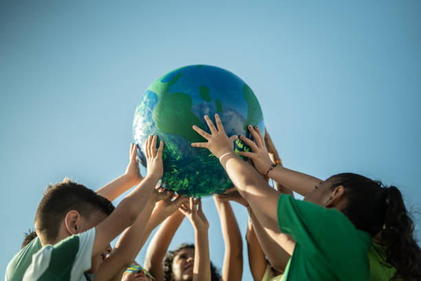дети держат планету на открытом воздухе - sustainable resources environment education cleaning стоковые фото и изображения