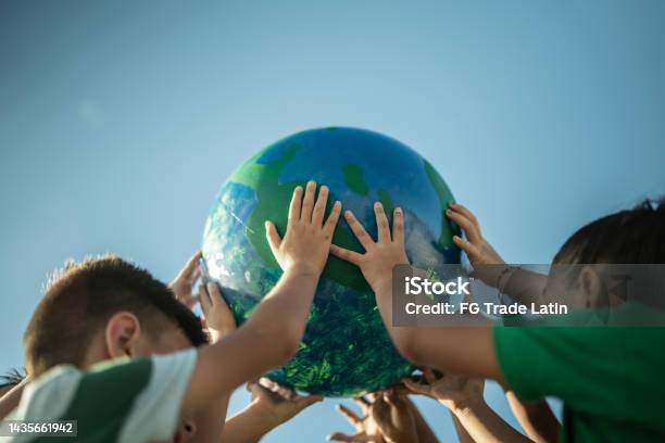 Children Holding A Planet Outdoors Stock Photo - Download Image Now - Earth Day, Child, Climate Action