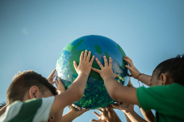 children holding a planet outdoors - sustainable resources environment education cleaning imagens e fotografias de stock