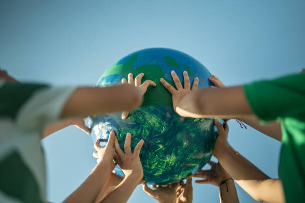 children holding a planet outdoors - sustainable resources environment education cleaning imagens e fotografias de stock