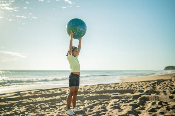 istock Girl holding a planet sphere at the beach 1435661988