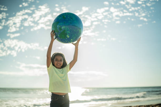 istock Girl holding a planet sphere at the beach 1435661995