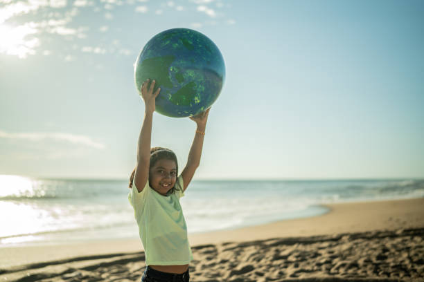 istock Girl holding a planet sphere at the beach 1435661996