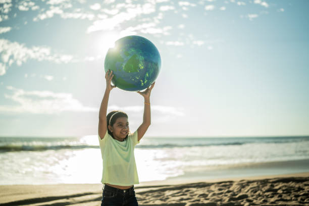 istock Girl holding a planet sphere at the beach 1435662019
