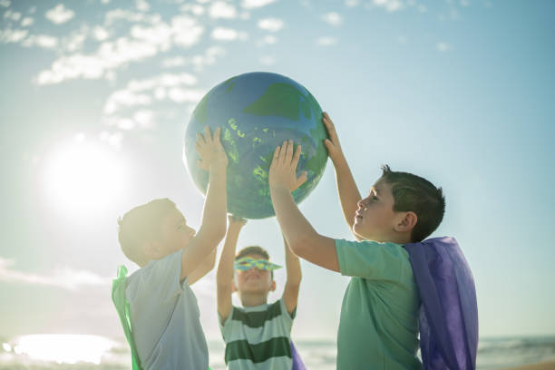 istock Boys holding an earth sphere at the beach 1435662059