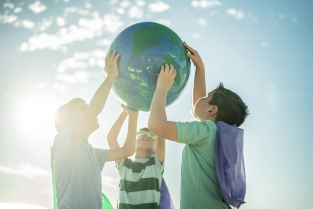 istock Boys holding an earth sphere at the beach 1435662065