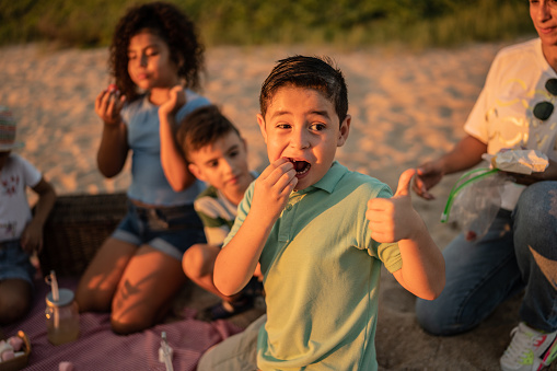 Boy eating on a picnic at the beach