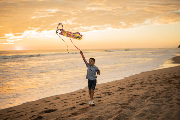 Boy playing with kite at the beach