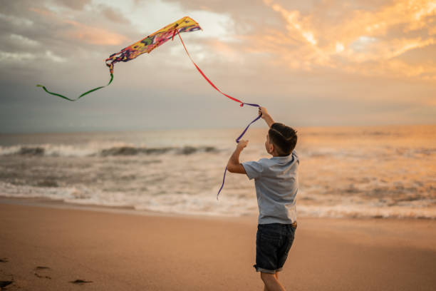 istock Boy playing with kite at the beach 1435663569