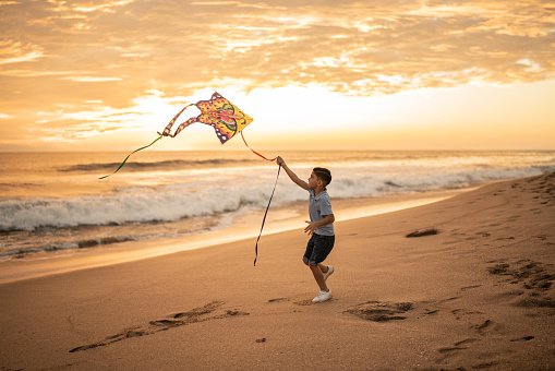 Boy playing with kite at the beach