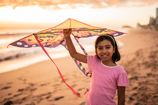 Portrait of girl holding a kite at the beach