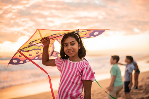 Portrait of girl holding a kite at the beach
