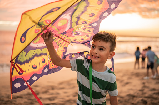 Boy holding a kite at the beach