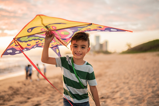 Portrait of boy holding a kite at the beach