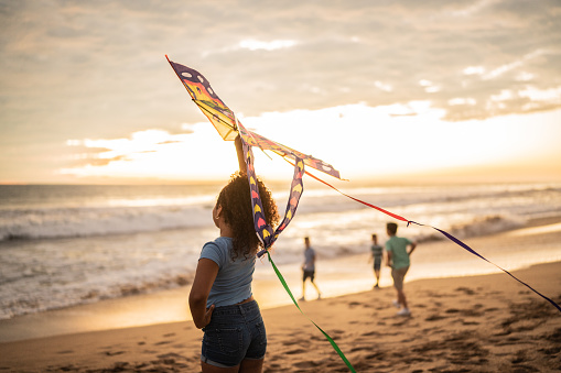 Girl holding a kite at the beach