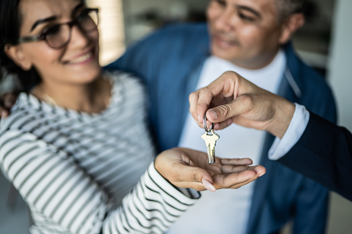 Close-up real estate agent giving the home keys to a customer