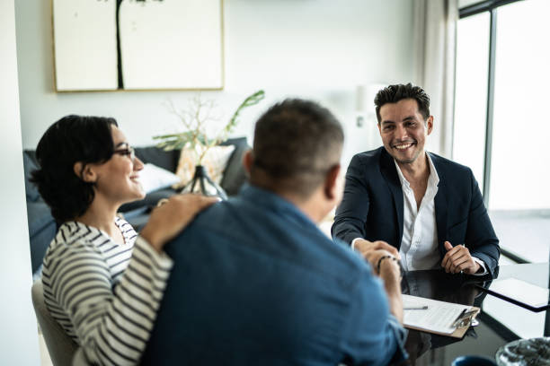 Mortgage broker smiling while shaking hands with a client