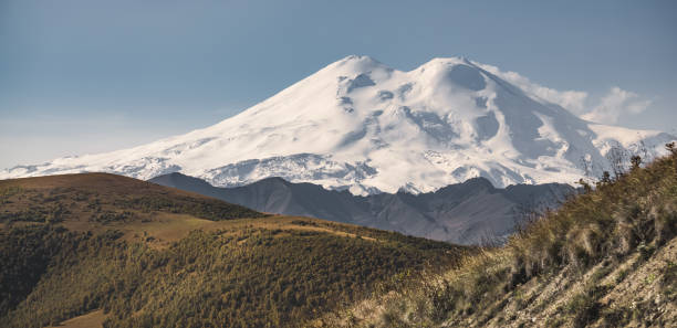 istock Mount Elbrus with two peaks and a hilly surrounding mountain landscape with a flattering array in warm yellow autumn hues, in the Caucasus in October 1435665406