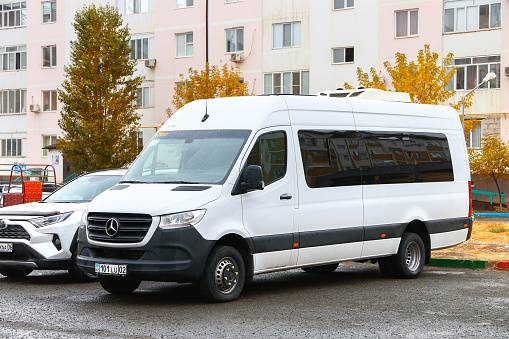 Atyrau, Kazakhstan - October 21, 2022: White passenger van Mercedes-Benz Sprinter in the city street.