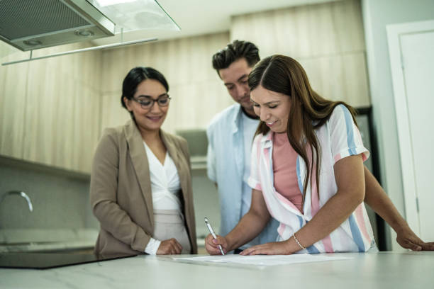 istock Mid adult couple signing documents at home 1435667162