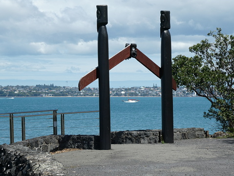 This is the wharf at the island of Rangitoto in Auckland New Zealand with a sailing yacht in the background.