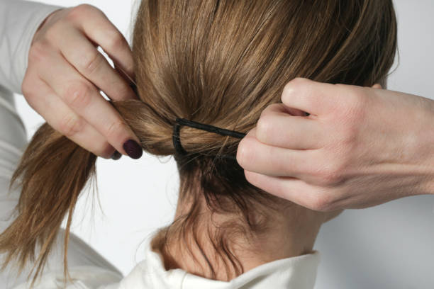 série de fotos de fazer um rabo de cavalo baixo com faixa de cabelo elástica básica. visão de trás da jovem mulher amarrou o cabelo em rabo de cavalo. - human hair ponytail women back - fotografias e filmes do acervo