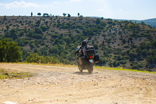 A man riding an off-road motorcycle on a mountain road