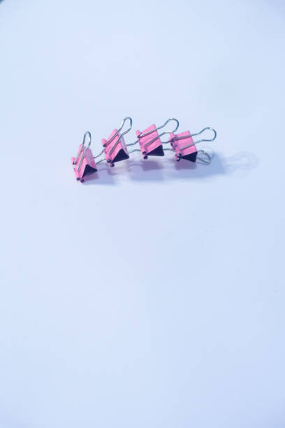 istock Four pink paper clips on White paper 1435692963