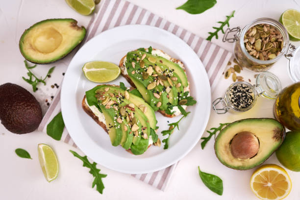 istock Freshly made Avocado and cream cheese toasts on a white ceramic plate and ingredients 1435693983