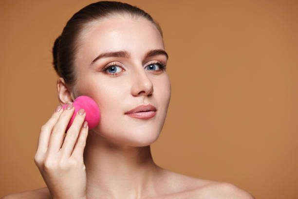 istock attractive young woman using pink cosmetic sponges 1435696208