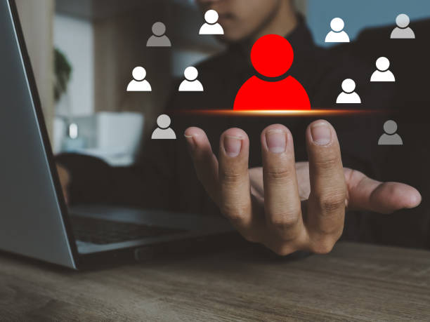 istock man's hand showing red selected person icon. 1435725743