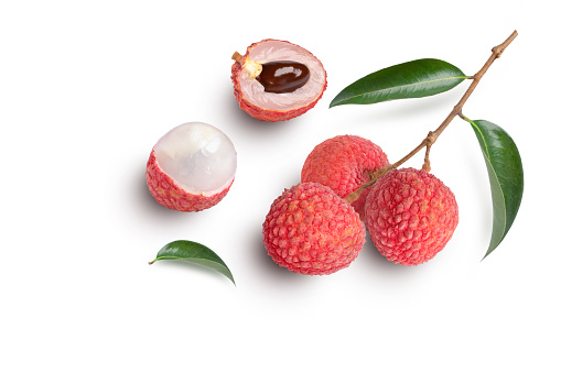 Fresh pile of lychees with leaves on stone background