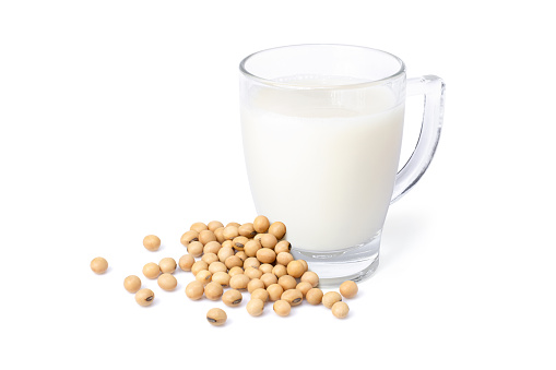 Glass of soy milk with soybean isolated on white background.