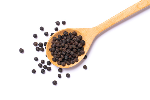 Black pepper seeds or peppercorns on white