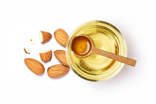 Almond oil and almond nuts in isolated on white background. Top view, flat lay.