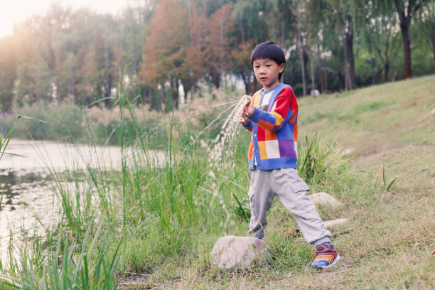 The little boy playing by the river looked at the camera