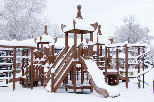 children's swing in winter in a park in the snow in Ukraine In the city of Dnipro, winter in the city