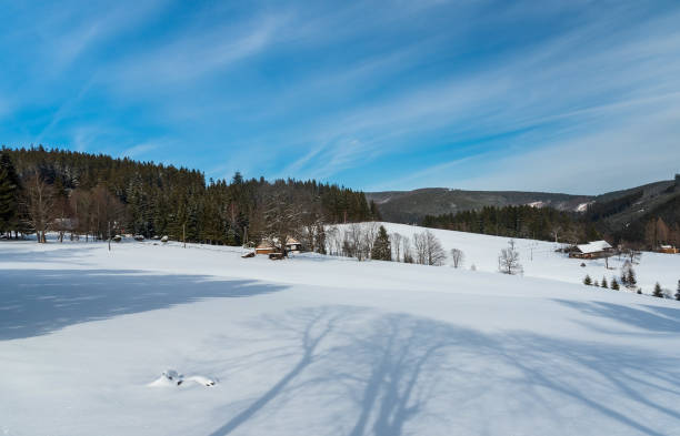 Winter Moravskoslezske Beskydy mountains scenery bellow Lysa hora hill in Czech republic Winter Moravskoslezske Beskydy mountains scenery bellow Lysa hora hill in Czech republic with snow covered meadow, few isolated houses, forest covered hills and blue sky with clouds moravian silesian beskids photos stock pictures, royalty-free photos & images