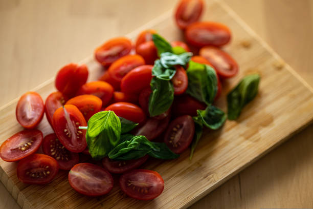 cherry tomato and basil on wooden background. Vegetable salad preparation. High-quality photo