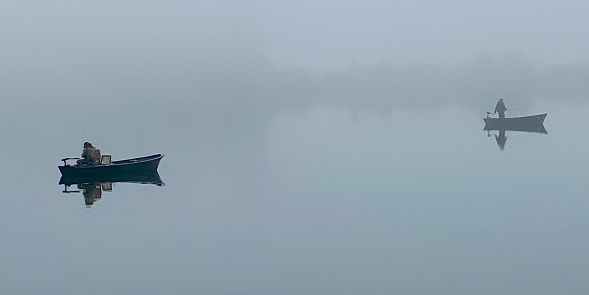 Fishing boats on a misty loch in Scotland