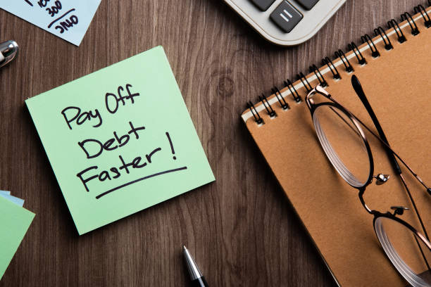 istock Pay off debt faster handwritten on memo and calculator. 1435761279