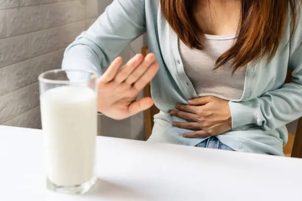 Female gesturing stop or say no to drink milk. Lactose intolerance, food allergy concept. Closeup