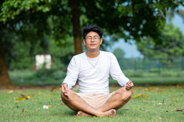 istock Young man practices yoga and meditation at park 1435772378