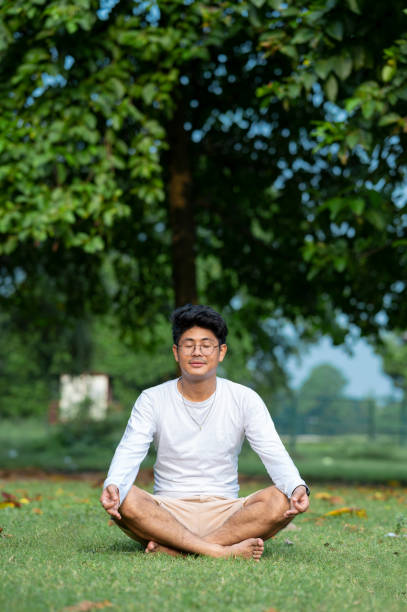 istock Young man practices yoga and meditation at park 1435772381