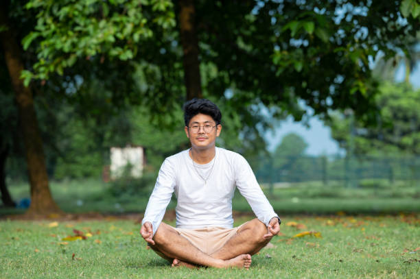 istock Young man practices yoga and meditation at park 1435772390