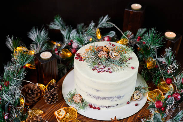 istock Christmas cake made of chocolate base with cream, decorated with spruce branches, walnuts and pomegranate seeds against the backdrop of Christmas decor 1435776584