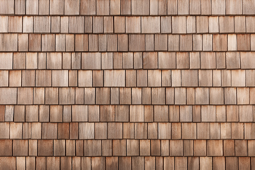 Close up looking down of New Cedar Shingle roof,gutters ,eaves and paned windows on a new home.