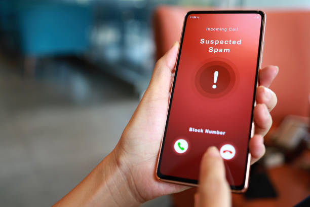 Person receiving suspected spam call on smartphone from an unknown caller A woman receiving an incoming suspected spam call on her phone. The network provider detect the scam and show warning sign to rejects the call suspicious message stock pictures, royalty-free photos & images