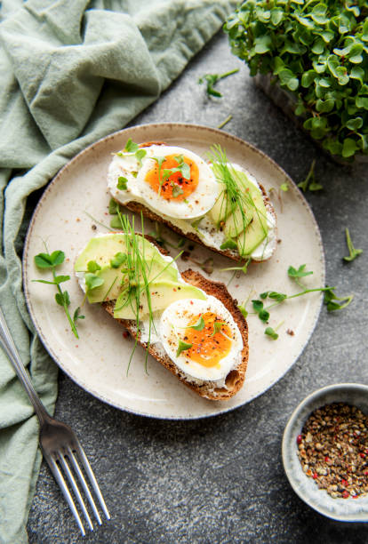 istock Bread toast, boiled eggs, avocado slice, microgreens on a plate 1435783948