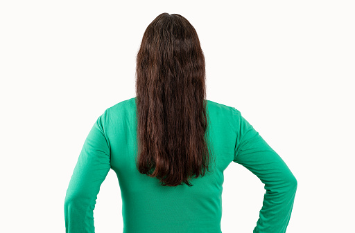 Young beautiful woman wearing green t-shirt standing over white isolated background standing backwards looking away with crossed arms
